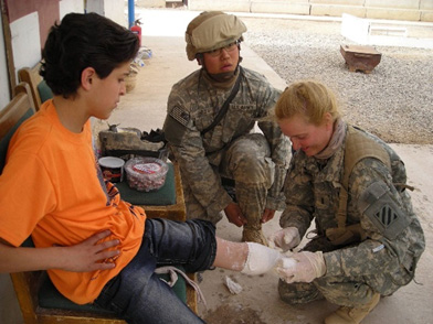 Terri and SGT Yandow fitting a young boy, Hussein, for a prosthetic.  Terri coordinated with Hangar in Columbus GA to donate a growing prosthetic for this boy who lost his leg in an IED blast.